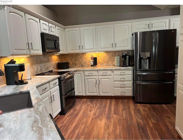 kitchen with sink, double oven range, refrigerator with ice dispenser, light stone countertops, and white cabinets