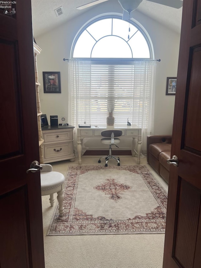 home office featuring a textured ceiling, vaulted ceiling, and a healthy amount of sunlight