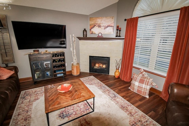 living room with wood-type flooring and a tile fireplace