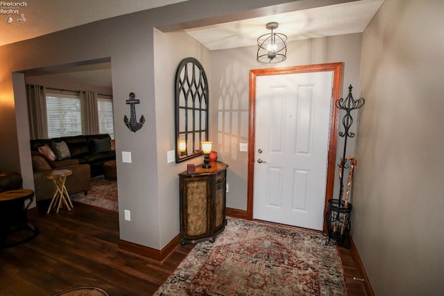 entrance foyer featuring dark hardwood / wood-style flooring and a notable chandelier