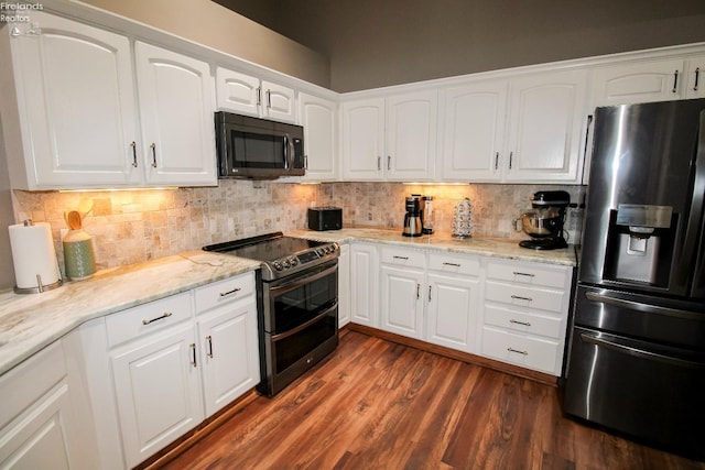 kitchen with light stone counters, tasteful backsplash, stainless steel appliances, and white cabinets