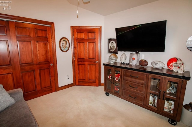 living room with vaulted ceiling and light colored carpet