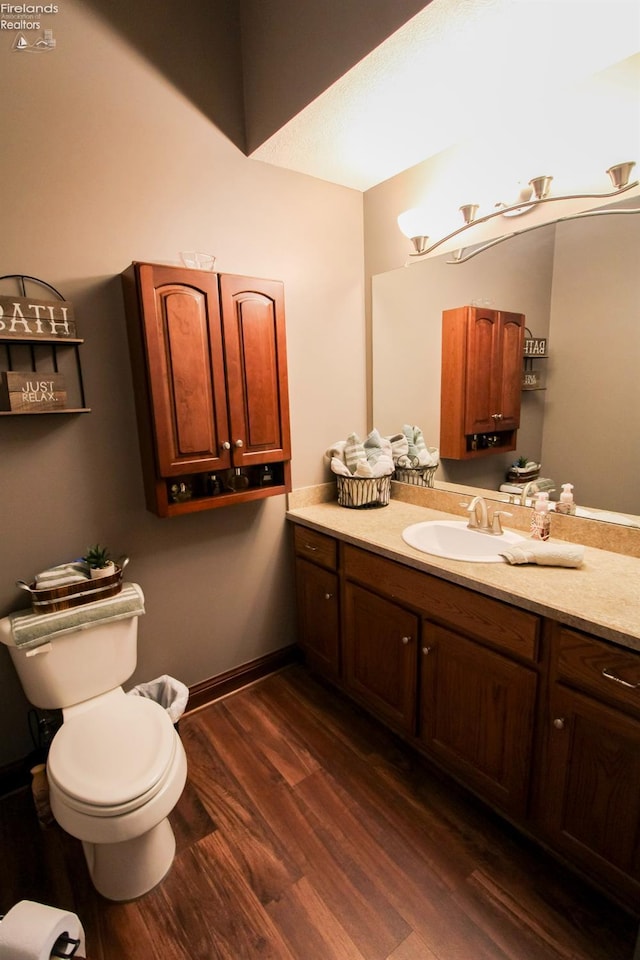 bathroom featuring vanity, hardwood / wood-style floors, and toilet