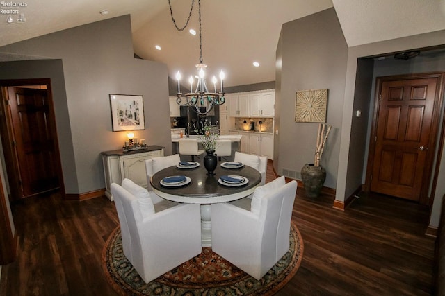 dining area with a notable chandelier, dark wood-type flooring, and vaulted ceiling