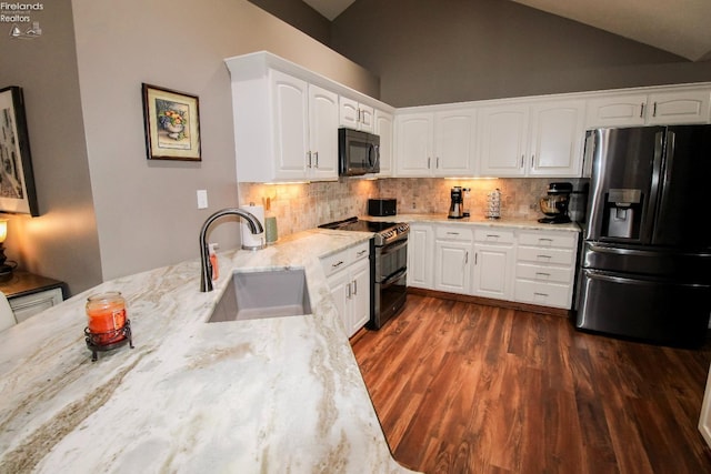 kitchen featuring lofted ceiling, sink, light stone counters, stainless steel appliances, and white cabinets