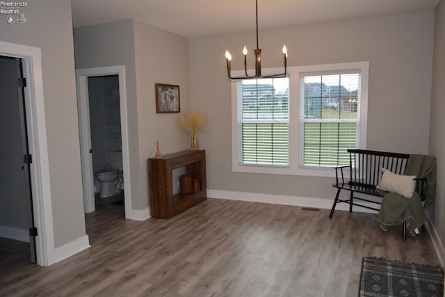 living area featuring hardwood / wood-style floors and an inviting chandelier