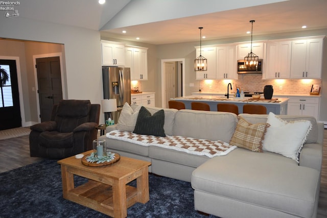 living room featuring lofted ceiling and sink