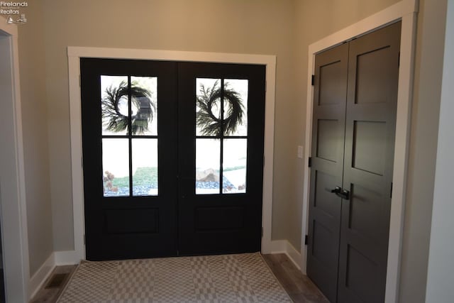 entrance foyer featuring dark hardwood / wood-style floors and french doors