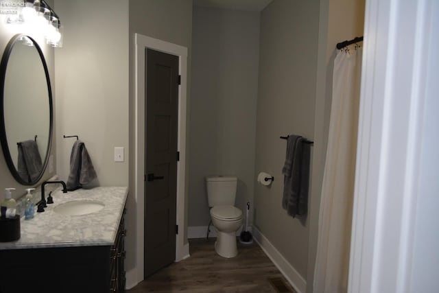 bathroom with vanity, hardwood / wood-style floors, and toilet