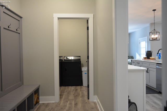 mudroom with a chandelier, separate washer and dryer, sink, and light wood-type flooring