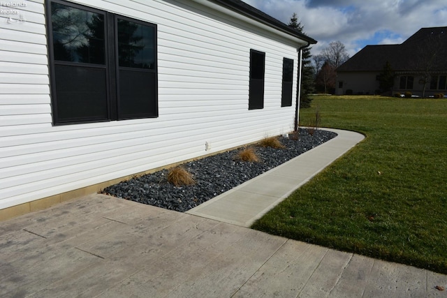 view of home's exterior with a patio and a lawn