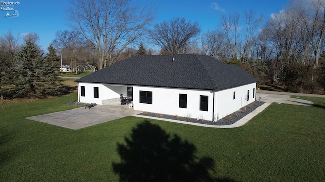 rear view of property featuring a lawn and a patio area