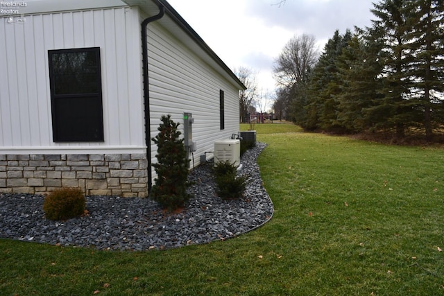 view of home's exterior featuring cooling unit and a lawn