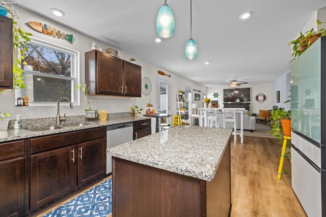 kitchen with pendant lighting, sink, dark brown cabinets, a center island, and stainless steel dishwasher