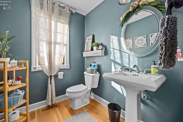 bathroom featuring wood-type flooring and toilet