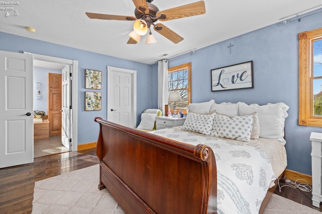 bedroom featuring hardwood / wood-style flooring, ensuite bath, and ceiling fan