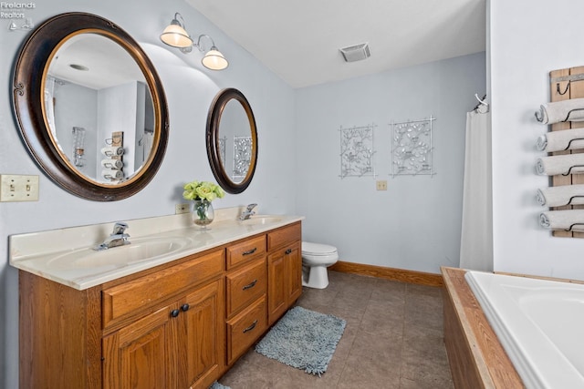 bathroom featuring vanity, a bathtub, tile patterned flooring, and toilet