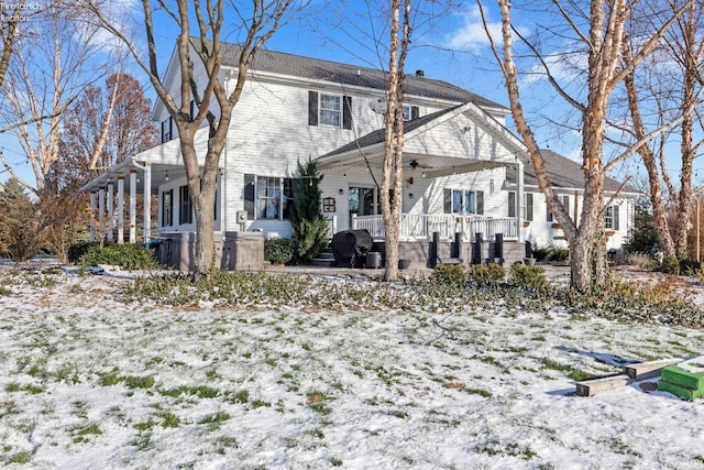 snow covered house featuring a porch