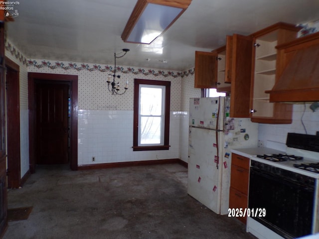 kitchen with premium range hood, white refrigerator, and gas stove