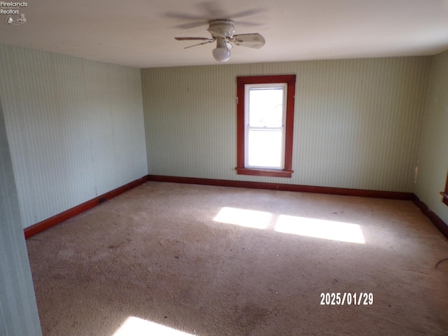 spare room featuring ceiling fan and carpet floors