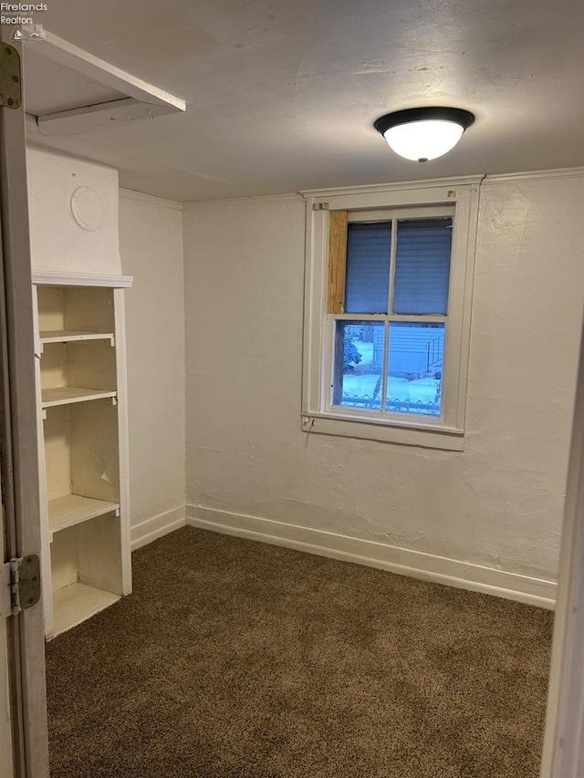 unfurnished room featuring dark carpet