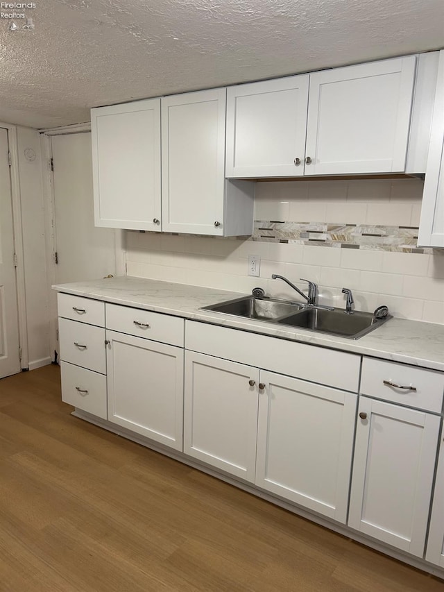 kitchen featuring sink and white cabinets