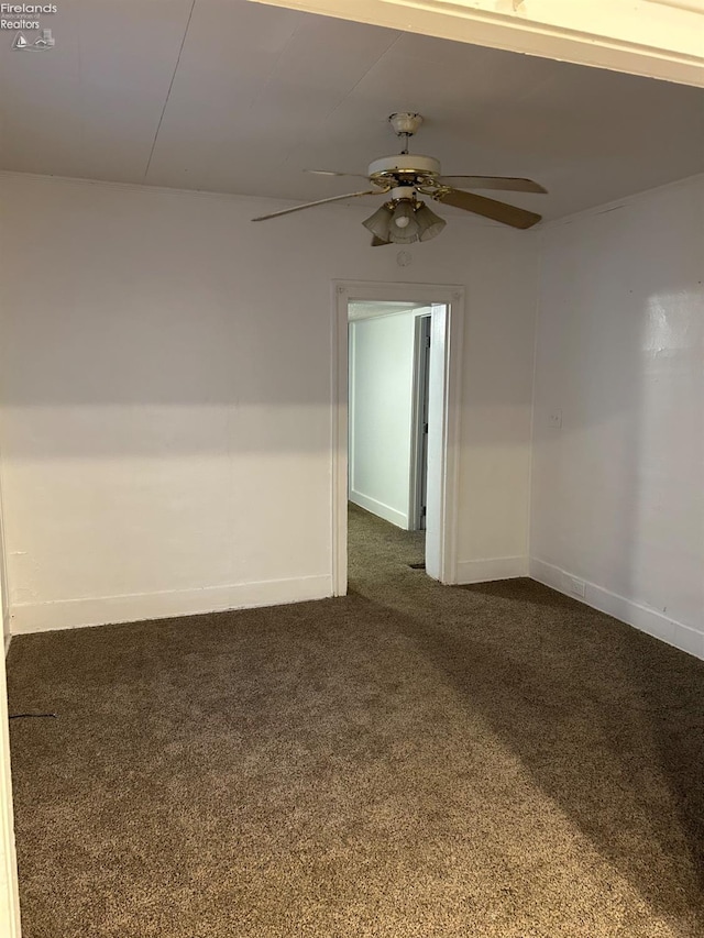 empty room with dark colored carpet and ceiling fan