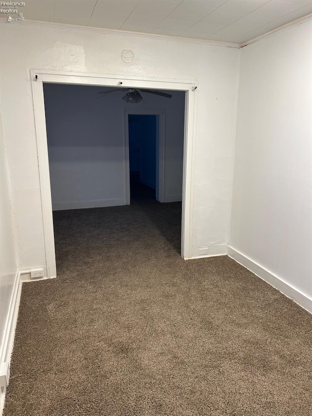 hall featuring dark colored carpet and crown molding