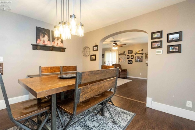 dining area with ceiling fan and dark hardwood / wood-style flooring