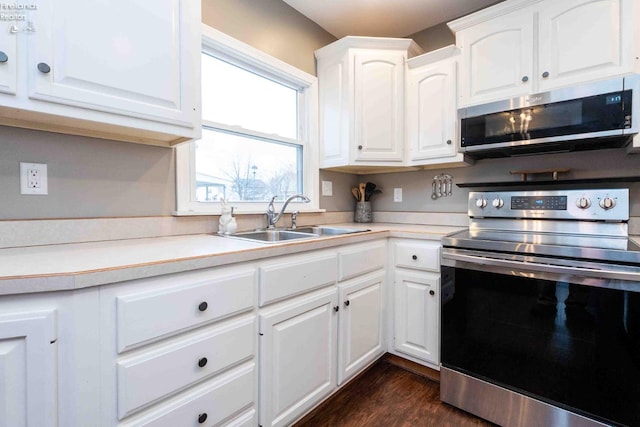 kitchen with white cabinetry, stainless steel appliances, dark hardwood / wood-style flooring, and sink