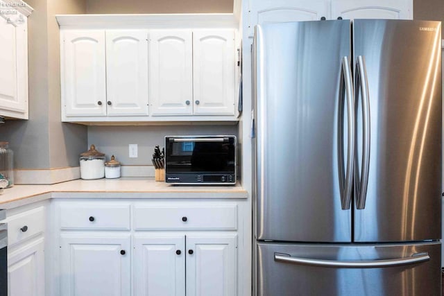 kitchen with white cabinetry and stainless steel fridge