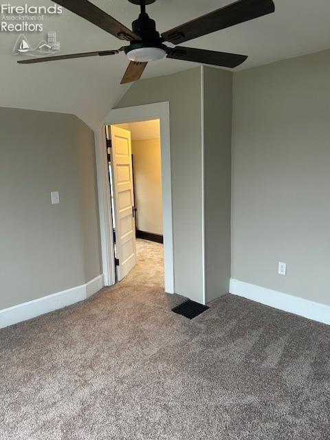 unfurnished room with ceiling fan, light colored carpet, and lofted ceiling