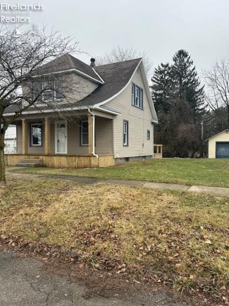 view of front of home featuring a garage, covered porch, and a front lawn