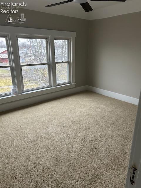 carpeted spare room with ceiling fan