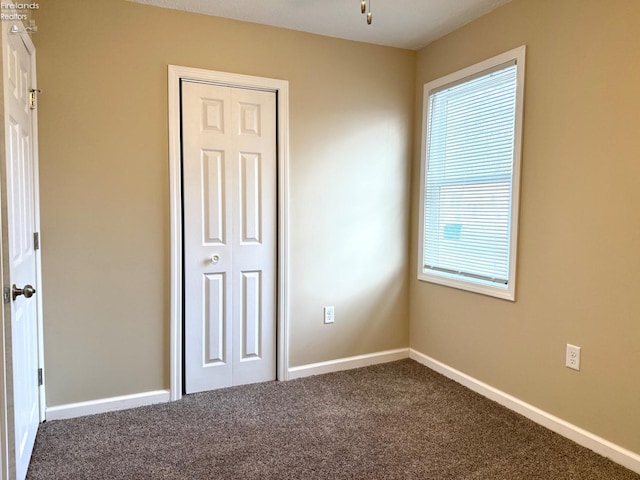 unfurnished bedroom with carpet flooring and a closet