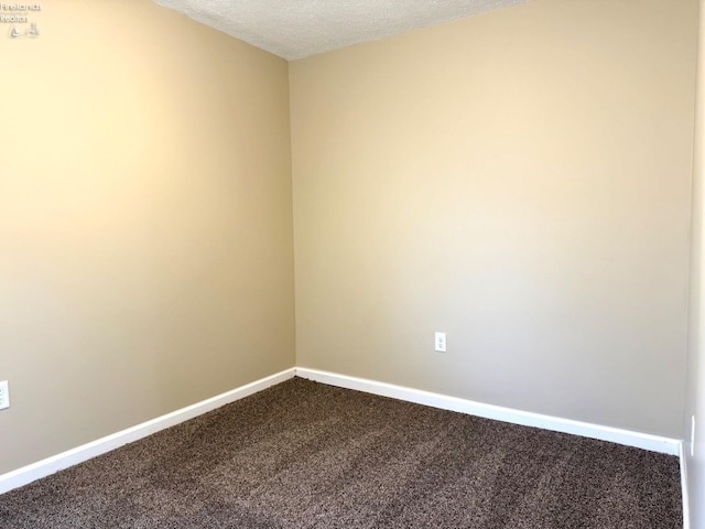 carpeted empty room featuring a textured ceiling