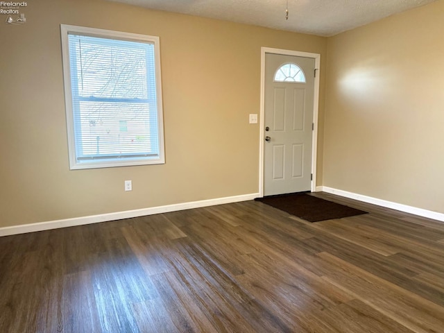 entrance foyer with dark hardwood / wood-style floors and a textured ceiling