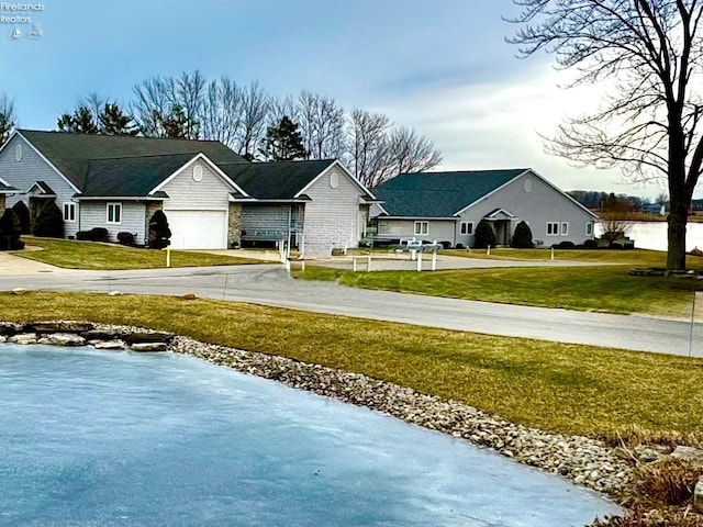 view of road with a garage and a lawn