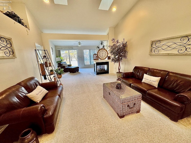 living room with ceiling fan, a multi sided fireplace, carpet flooring, and high vaulted ceiling