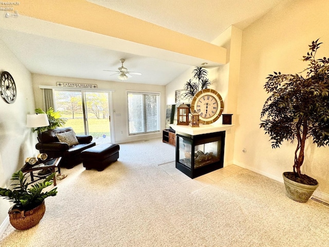 carpeted living room with ceiling fan, a multi sided fireplace, and vaulted ceiling