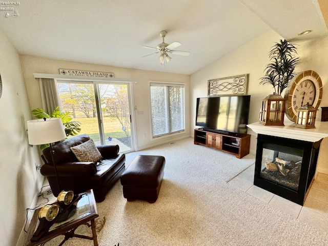 living room featuring ceiling fan, a multi sided fireplace, vaulted ceiling, and light carpet