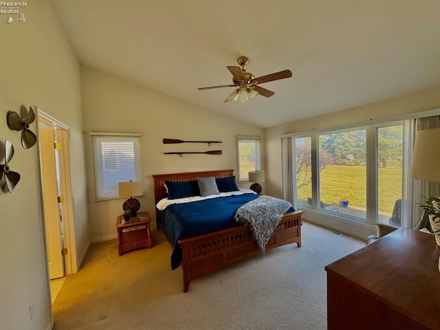 bedroom featuring multiple windows, vaulted ceiling, and light carpet