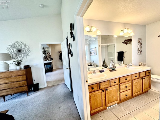 bathroom with vanity, walk in shower, toilet, tile patterned floors, and a textured ceiling