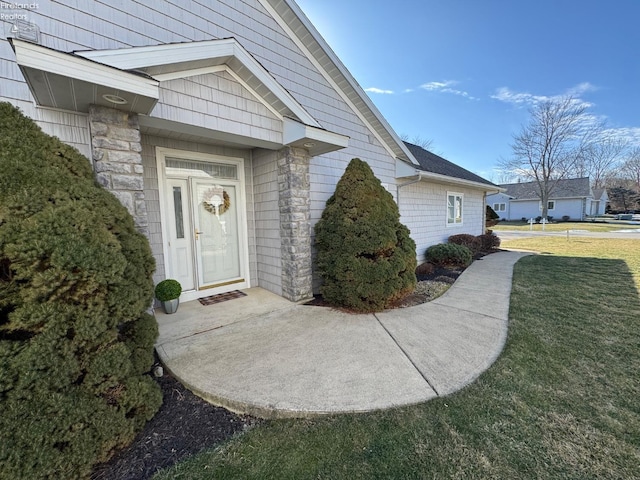 property entrance with a lawn