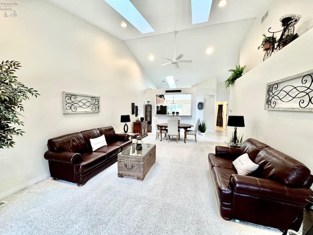 living room with ceiling fan, light colored carpet, high vaulted ceiling, and a skylight