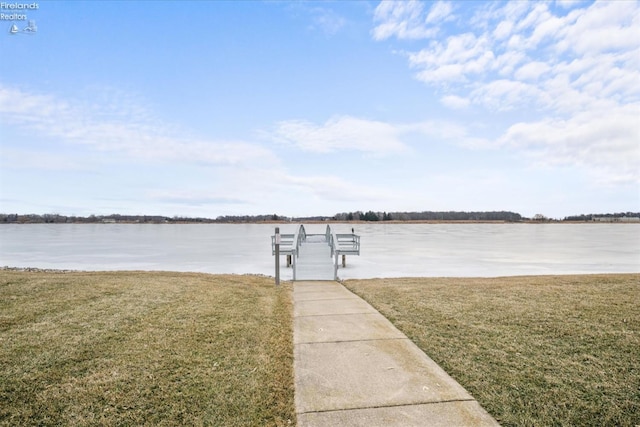 view of dock with a water view and a lawn