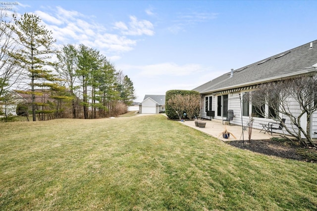 view of yard with a garage and a patio area