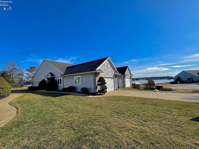 view of home's exterior featuring a water view, a garage, and a lawn