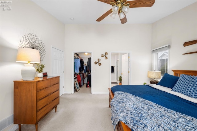 carpeted bedroom with a towering ceiling, a spacious closet, connected bathroom, and a closet