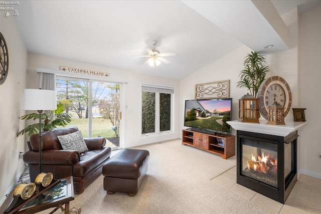 living room with light carpet, vaulted ceiling, ceiling fan, and a multi sided fireplace